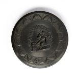 A 19th Century circular pressed horn snuff box, the cover with a figure of a man drinking ale,