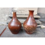 An unusual 'similar' pair of ovoid shaped terracotta wine flasks with dark glaze.