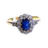 A sapphire and diamond oval cluster ring, yellow gold with diamond set shoulders,