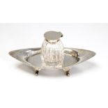 A George V silver plain navette shaped ink stand on four scroll and ball feet,