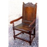 A Queen Anne period joined oak Wainscot armchair, circa 1710, with carved cresting rail,