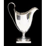 A George III silver plain helmet shaped cream jug, engraved with initial,