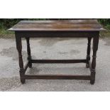 A late 17th Century joined oak side table, having a two-plank top, raised on turned columns,