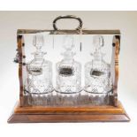 Edwardian three bottle EPNS Tantalus with silver whisky