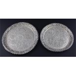 A near matched pair of Islamic white metal circular dishes, having pierced sides and rims, the