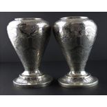 A pair of Iranian white metal baluster vases, having alternating panels engraved with figures and