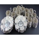 A set of twelve Iranian white metal cups and saucers, the cups having pierced side, chased and