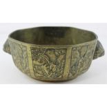 A late 19th Century Chinese bronze octagonal bowl, with mask head handles, engraved to the sides