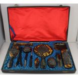 A cased Chinese tortoiseshell dressing set, with dragon motifs.