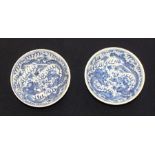 A pair of Chinese blue and white shallow bowls, painted in under glaze blue with five claw dragon