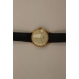 A Gentleman's eighteen carat Gold Realm slim line watch with leather strap