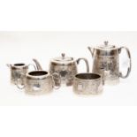 A George VI silver five piece tea service chased with with flowers and foliate band with vacant