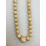 A string of graduated ivory beads, late 19th century, being formed from spherical ivory beads,