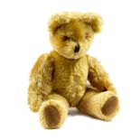 A circa 1950's golden plush musical teddy bear, the ears incorporating bells,