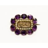 An early Victorian yellow metal, amethyst and seed pearl mourning brooch, of ovoid form,