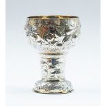 A German 17th Century parcel-gilt goblet, the bowl chased with ribbon tied fruit and flowers ,