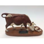 A Beswick - connoisseur model on stand of a Hereford cow and calf