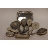 A matched Edwardian silver dressing table set including shaped oblong tray; four brushes, mirror,