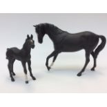 Two Beswick black mat unglazed bisque horses comprising a large black horse and a foal (2)