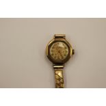 A Ladies vintage 9 ct gold wristwatch on a plated expanding bracelet