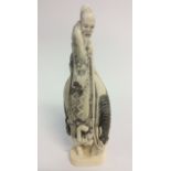 A signed Japanese Ivory carving of a wise man mounted on a horse,