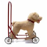 A circa 1960's Pedigree child's sit on/push along dog on wheels, wearing a collar, red metal frame,
