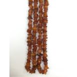 A 1920's long amber necklace of rough shaped beads