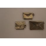 Three silver novelty stamp holders in the form of envelopes, the larger one Birmingham, dated 1912,