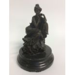 A Bronze female seated reclining figure. 21cm in height.