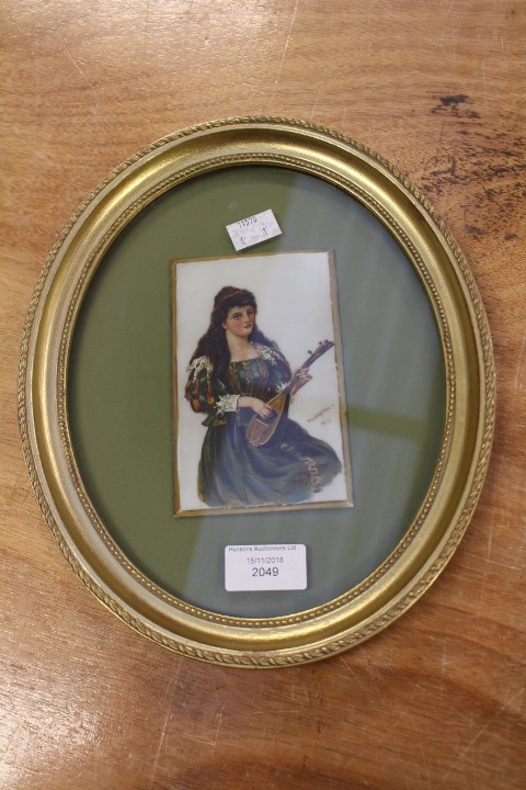 A late Victorian painting of a female mandolin player on opaque glass, signed D. L.