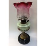 A Victorian brass mounted painted Vaseline glass oil lamp,