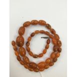 A single strand amber necklace, of graduated oval beads, approx 75 cm long/30 inches oval,