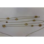 A long yellow metal chain with faceted citrine style stones