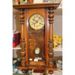 A late 19th century walnut eight day Vienna wall clock, split turned columns to door,