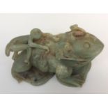 A large Chinese carved green soapstone figure of a toad with a monkey on its back,