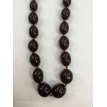 A string of black cherry coloured beads,