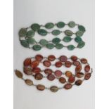 A vintage agate necklace comprising flat oval optical set beads, white metal surrounds,