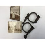 A pair of handcuffs used in the Boer War to shackle POW's, together with two photographs.