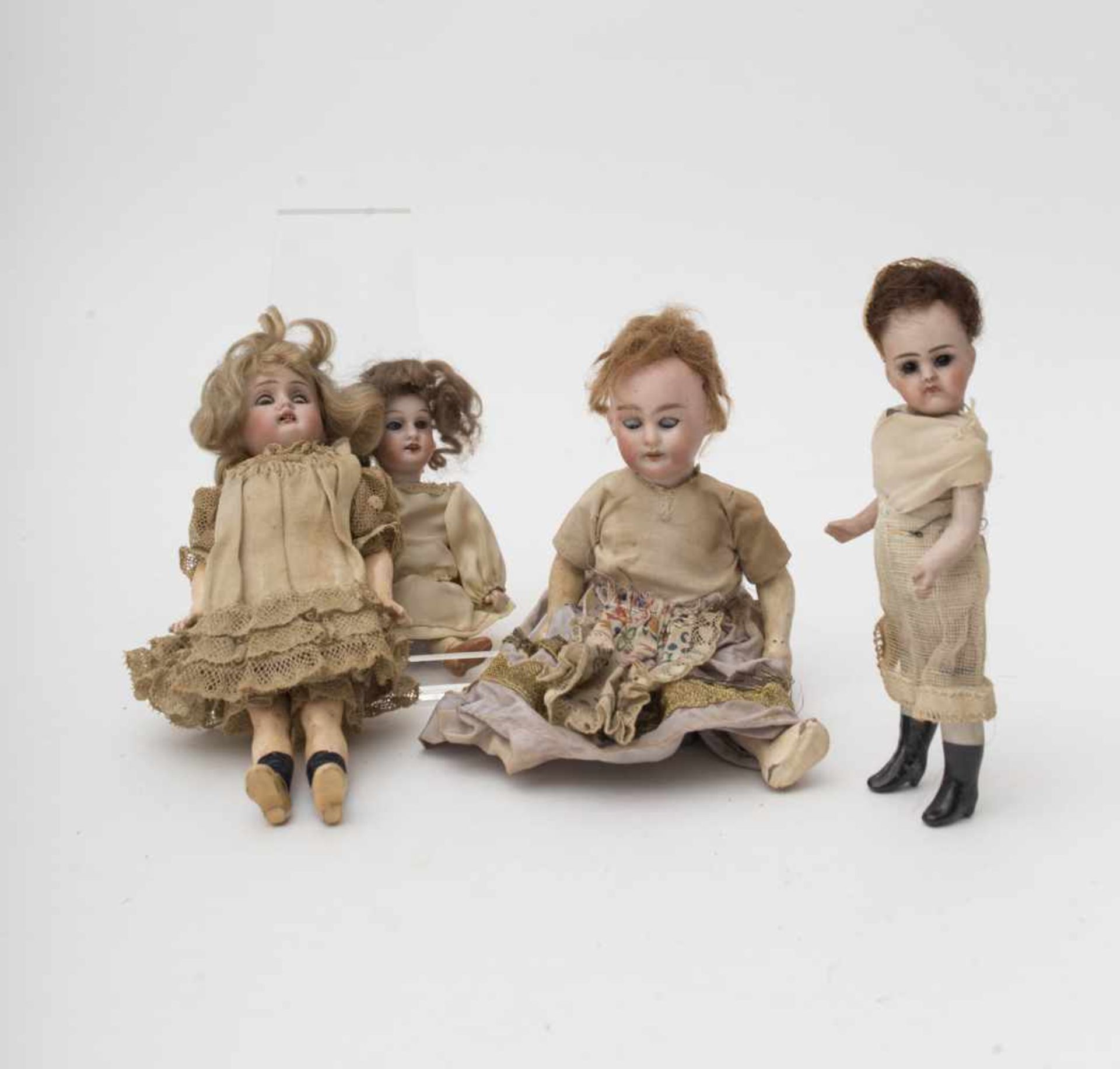 Four dolls With biscuit head, open mouth, of German make, composition and biscuit body, H=from 15 to