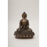 Buddha Vajrasana, NepalBronze with silver inlays, wearing draped clothing. Bearing a text in