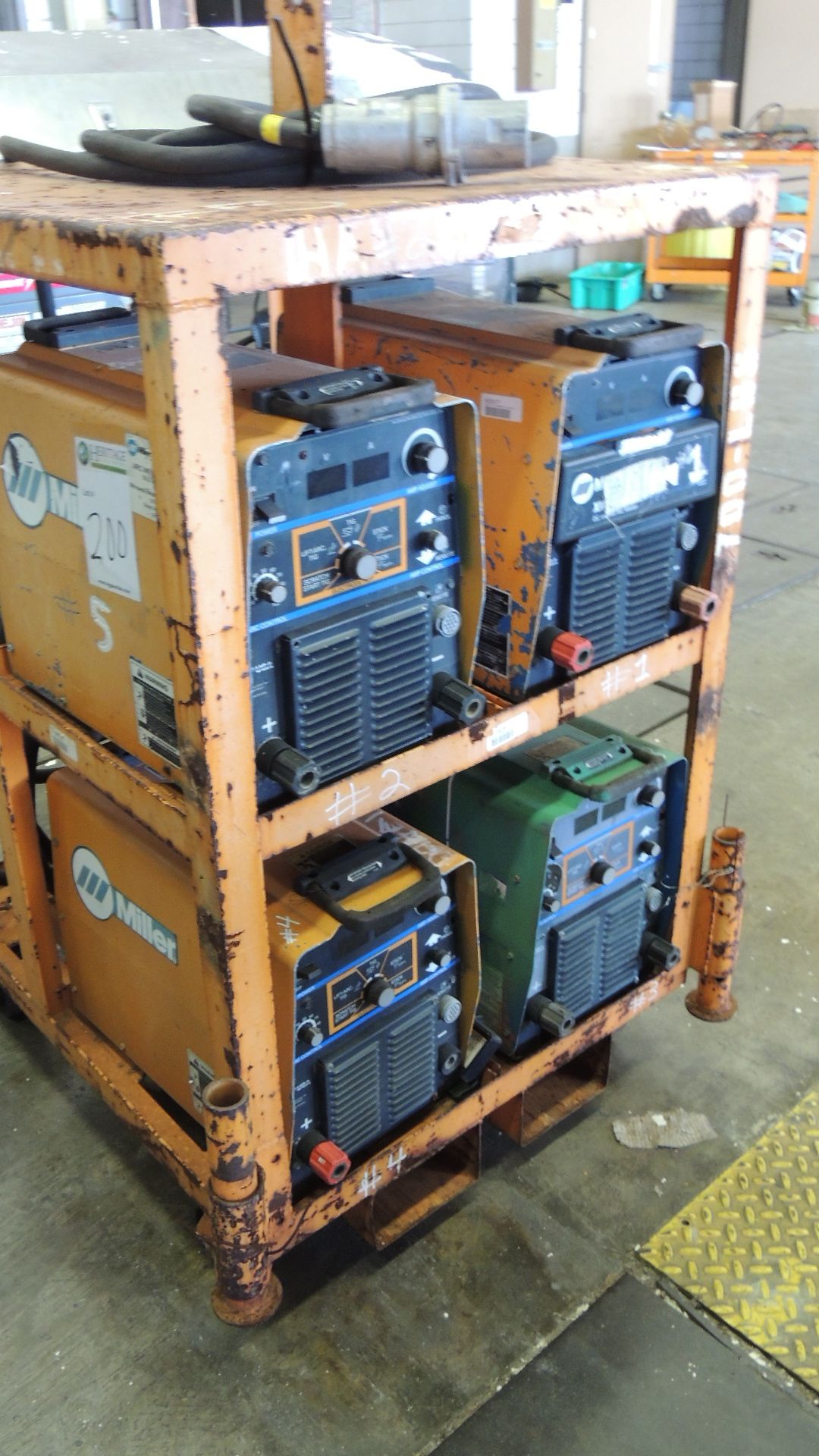 Welders. Miller (4) welders on rack w/ casters, stock # 903474, 230/460v. HIT# 2230893. Support