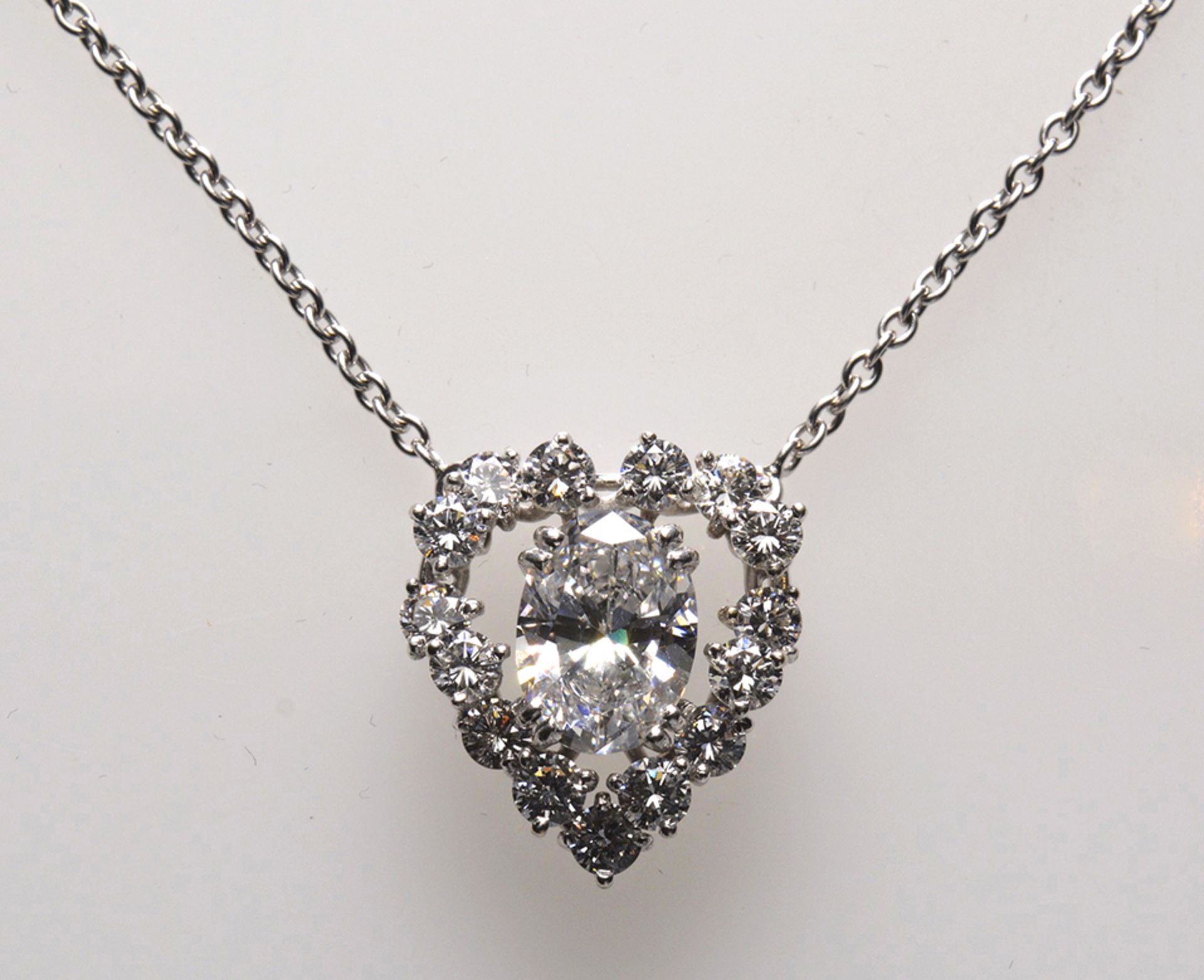 Heart-shaped pendant - Circa 2cts oval-cut diamond. Surrounded by round diamonds, [...]