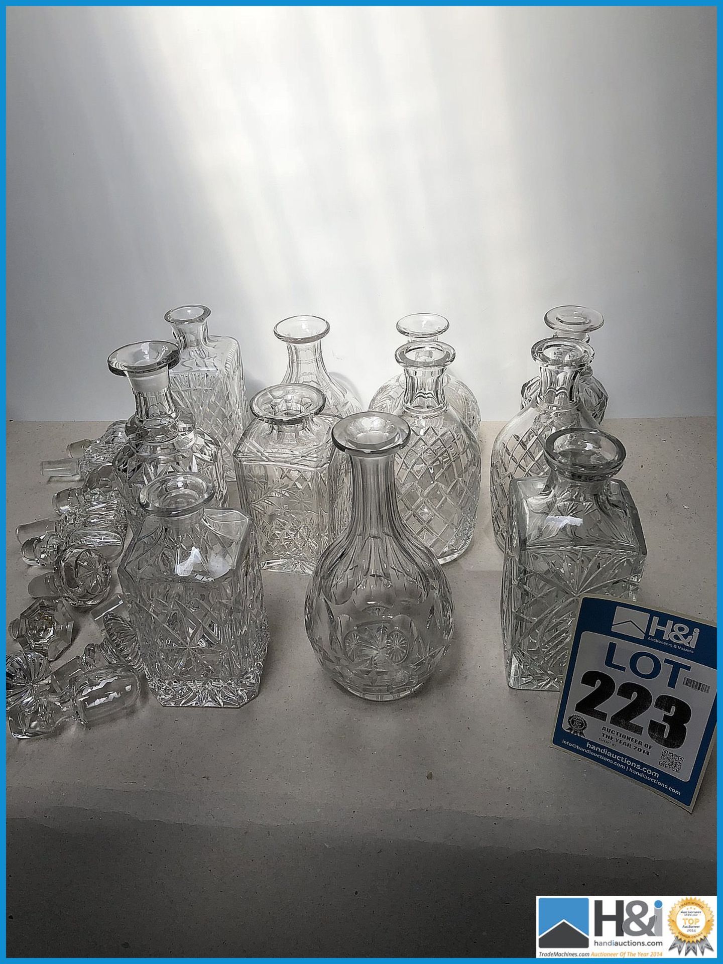 11 cut glass decanters with stoppers.