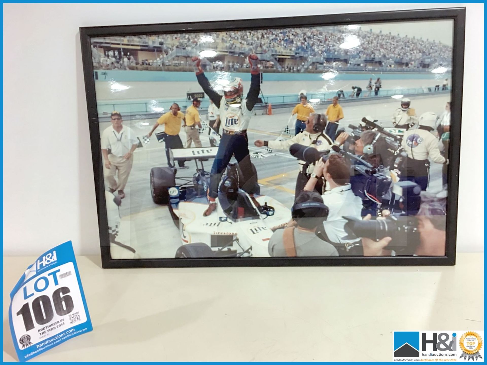 Framed photograph of Indycar race winner. Picture has minor damage. Appx 27in x 18in. From the Coswo