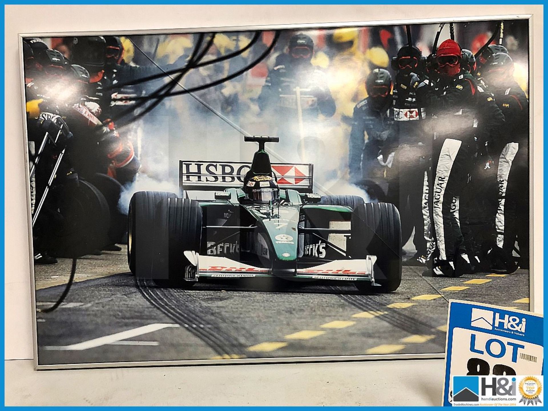 Ex Cosworth works framed print of F1 car leaving pits. Approx 30in x 20in. Crack in glass. Aluminium - Image 2 of 2