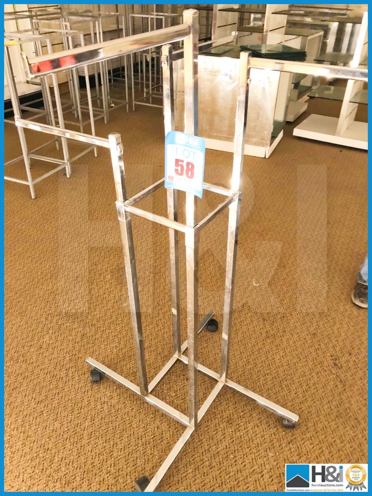 Chrome four armed clothes display stand on wheels free standing.