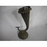 An Indian silver coloured metal horn shaped vase with repousse decoration of flowers, on circular