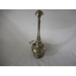 An Indian silver coloured metal rose water sprinkler with repousse decoration of flowers and