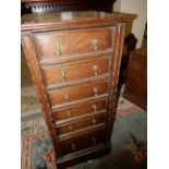 A 1930's oak Wellington chest fitted seven drawers, on platform base - 18in. wide