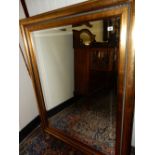 A large rectangular bevelled wall mirror in a gilt and silvered frame - 58in. x 45 1/2in.